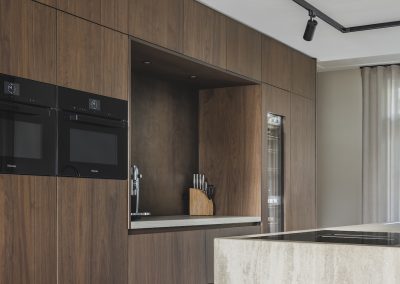 Houten kastenwand met inbouwapparatuur en nis in moderne keuken