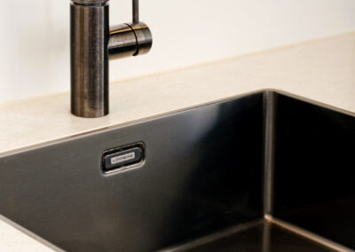 Moderne keuken met zwarte spoelbak en stijlvolle kraan.