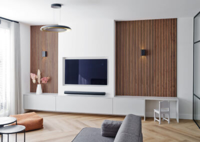 Moderne woonkamer met tv-wand, houten panelen en minimalistisch interieur.