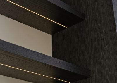 Donkere houten planken met geïntegreerde verlichting in moderne wand.