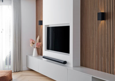 Moderne tv-wand met houten latten, strak meubel en minimalistisch design.