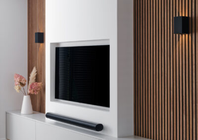 Moderne tv-wand met houten latten, strak meubel en minimalistisch design.
