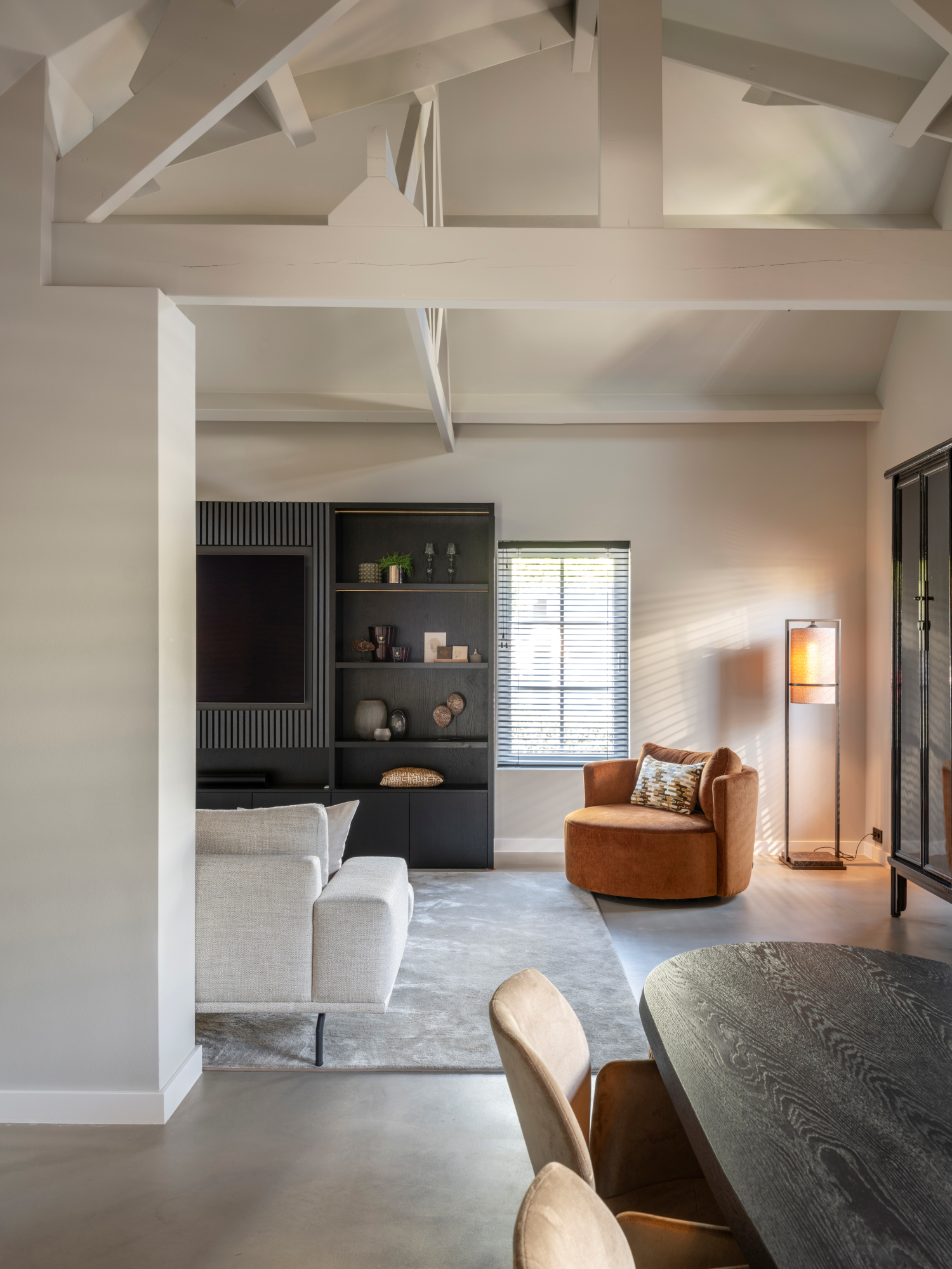 Moderne woonkamer met lichte bank, fauteuil en kastenwand