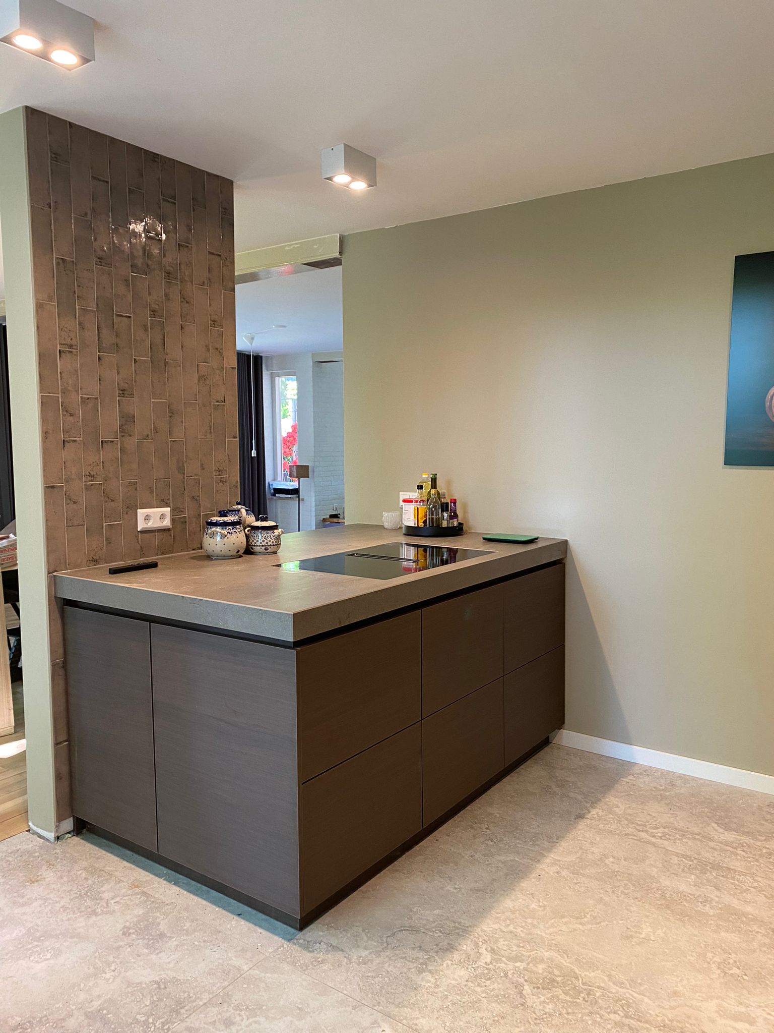 Kookeiland met houtafwerking Compact kookeiland met houten afwerking en licht werkblad in een moderne keuken.