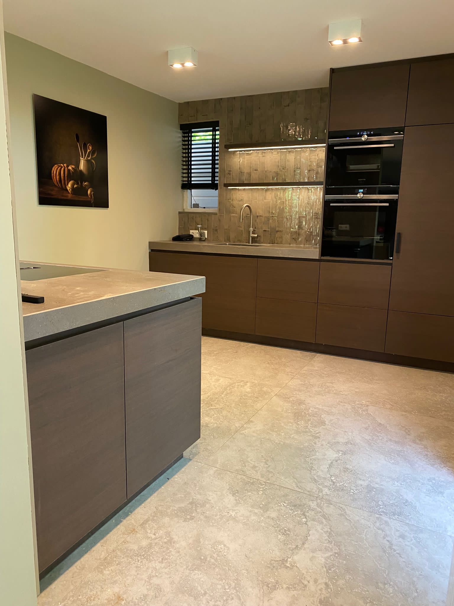 Moderne keuken met eiland Moderne keuken met kookeiland, houten kasten en ingebouwde oven.